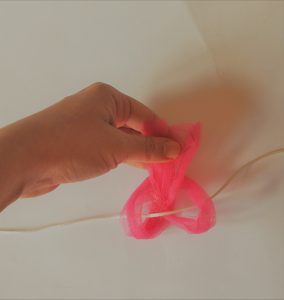 Enlazando la tira de tul en la cinta elástica
