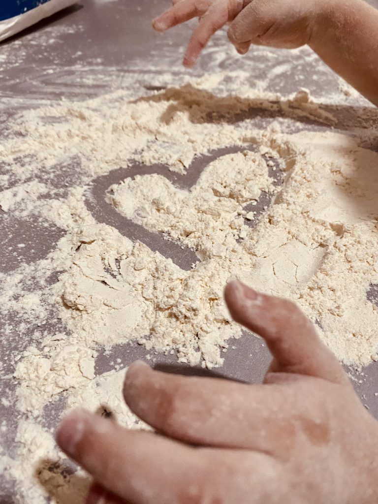 manos de niña jugando con harina 