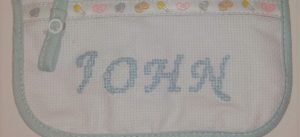 Babero bordado en punto de cruz por mamá low-cost