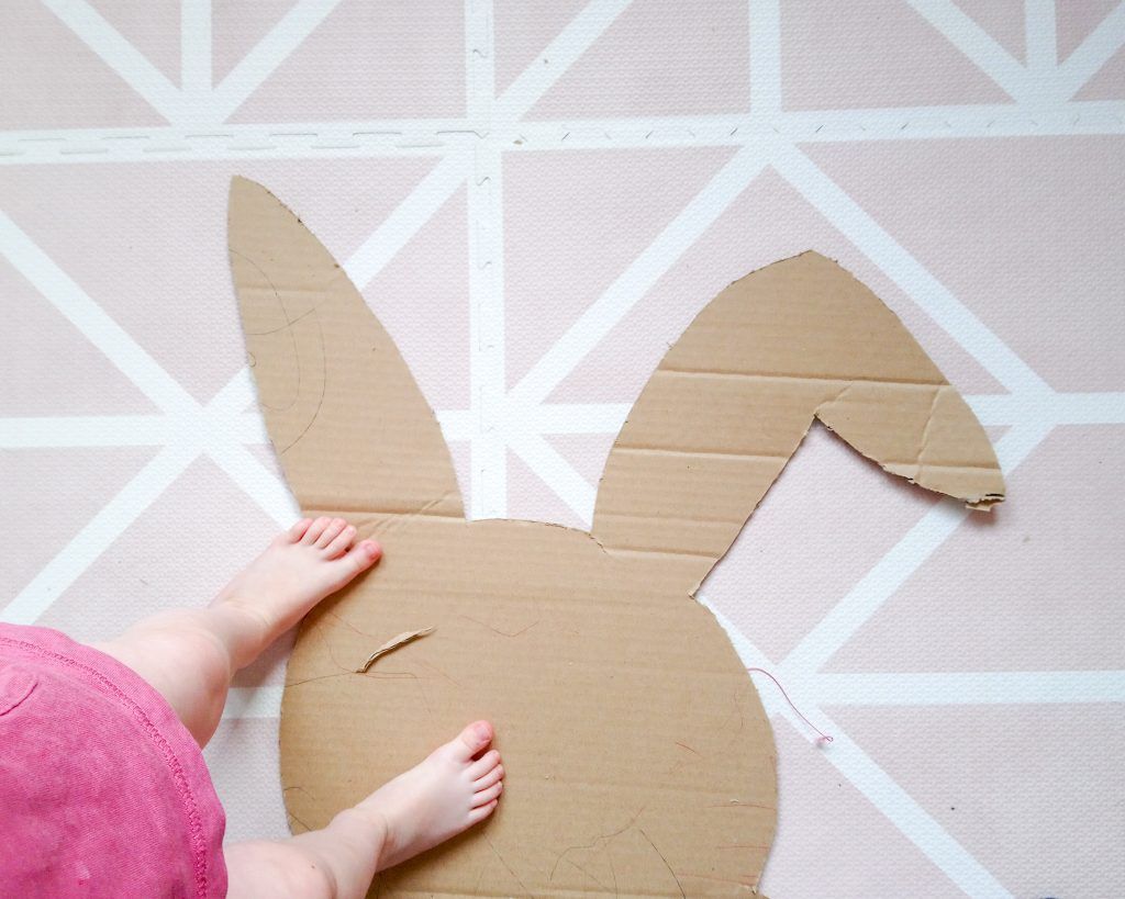 silueta de la piñata en el cartón ya recatad con pies de niña encima.