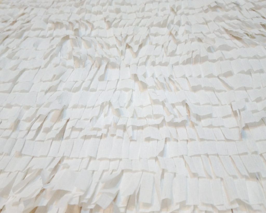 Pegar las tiras de abajo hacia arriba para que queden los flecos al aire.