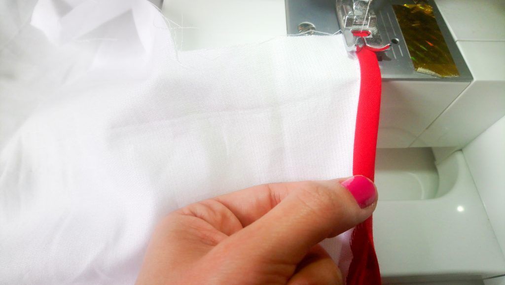 Pegar el bies o sesgo alrededor del delantal, dejando unos 15cm o más enlos laterales para poder atarles a la espalda.