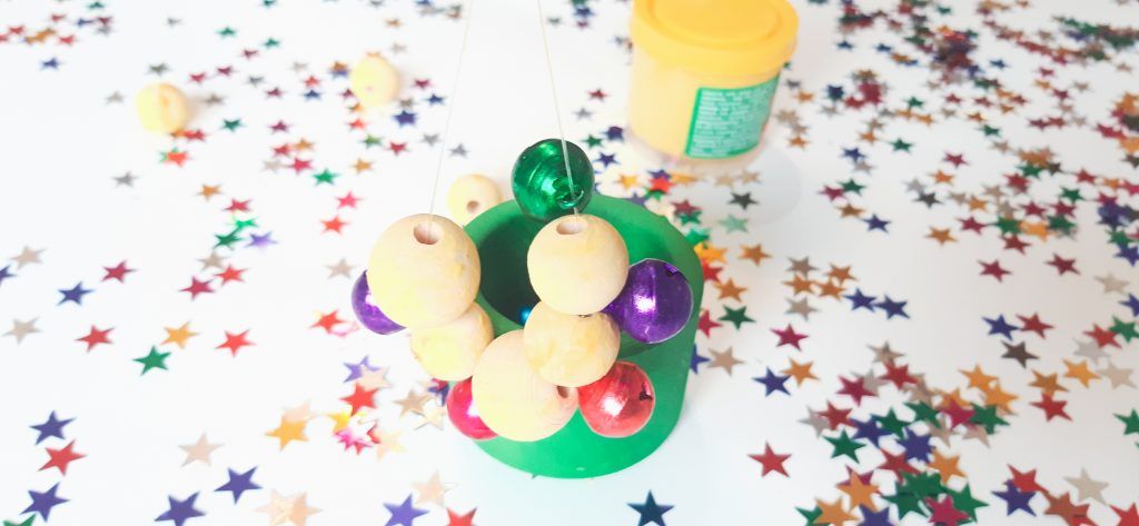 Pulsera o guirnalda de cascabeles y cuentas de madera.