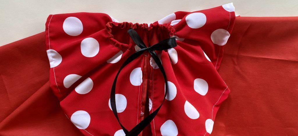 Voltear el cuello y hacer un ribete para meter la cinta.