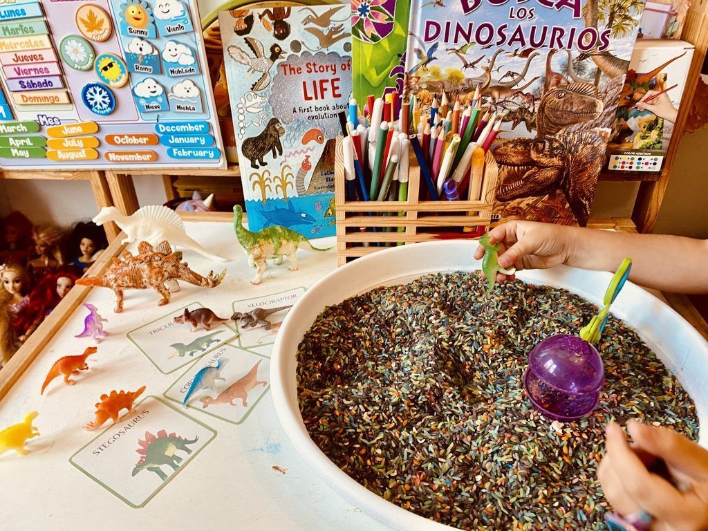 Buscando dinosaurios en un bol de arroz teñido. Dinosaurios y material imprimible