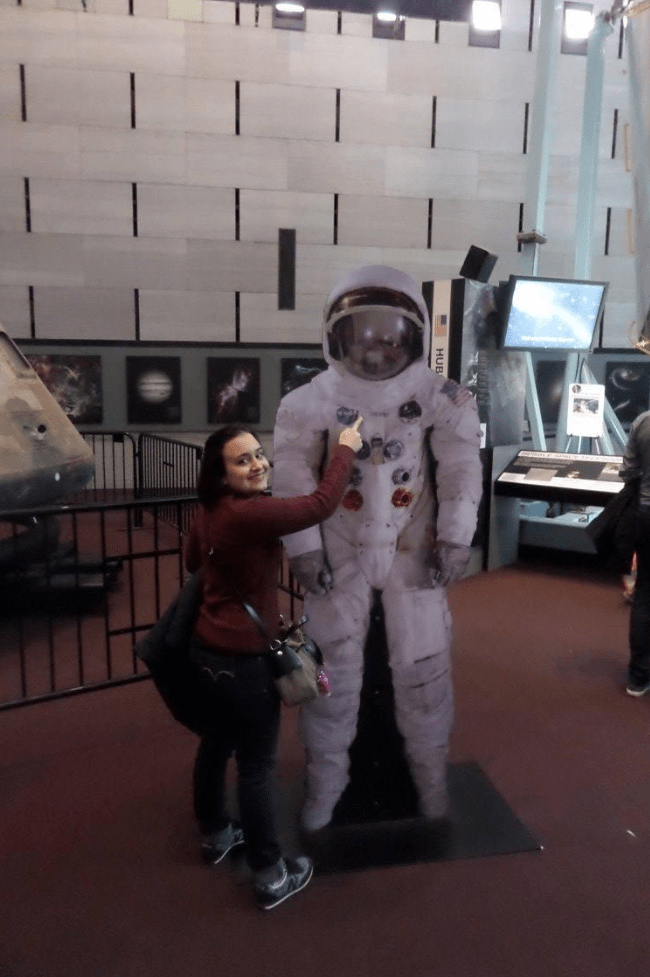 Mujer junto a traje de astronauta museo del aire y el espacio en Washington dc