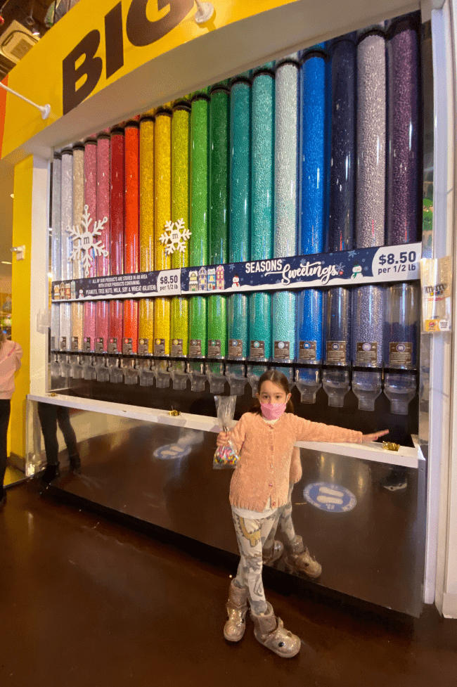Niña de 6 años en tienda m&ms. new York con niños
