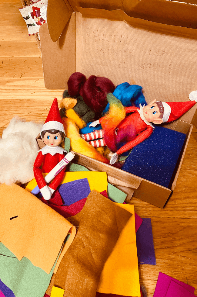 Dos elfos metidos en una caja con material de manualidades