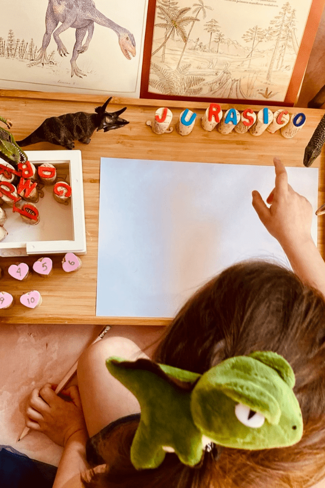 niña de cuatro años estudiando los dinosaurios
