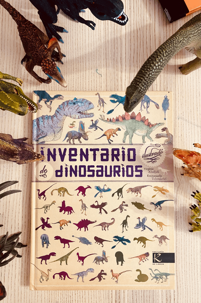 Libro llamado inventario de dinosaurios con dinos alrededor
