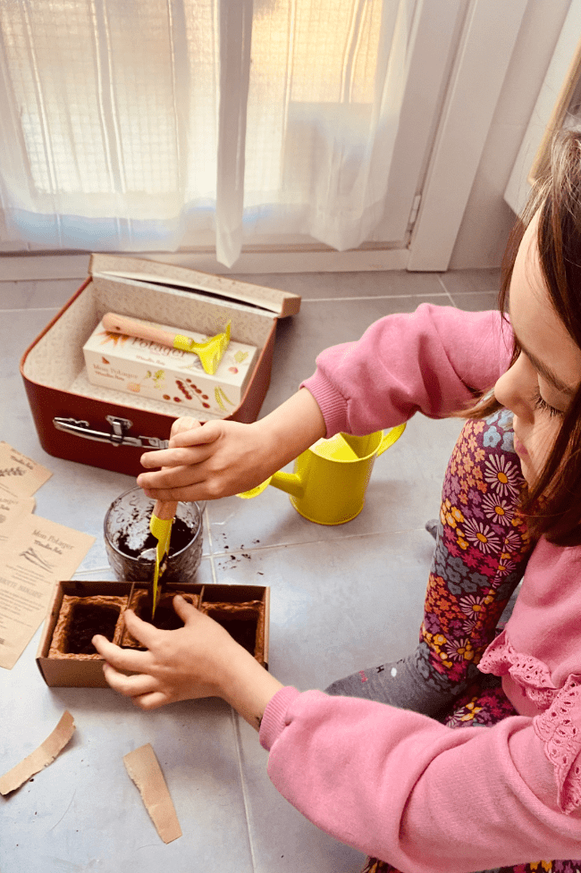 niña de seis años sembrando semillas