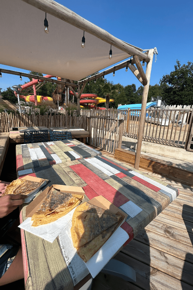 crepes de chocolate en una mesa y detrás el parque acuático del camping . Qué ver en Burdeos en pocos días con consejos low-cost