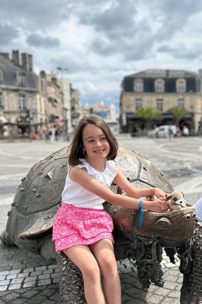 tortuga gigante de bronce con niña sentada al frente