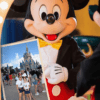 Mickey sujetando foto de familia ahorrar en los parques de orlando