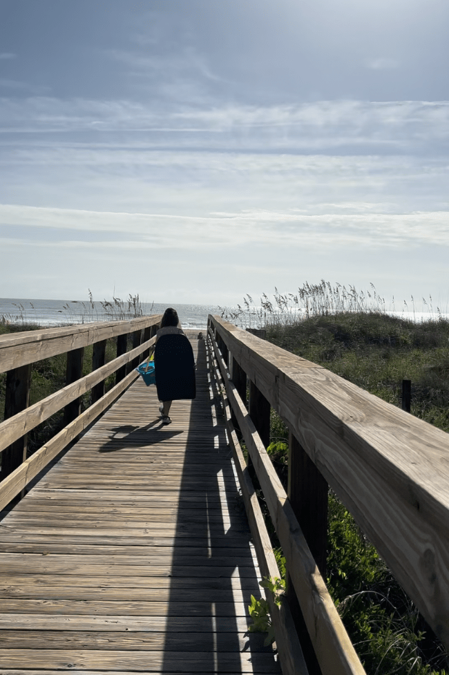 niña caminando hacia la playa